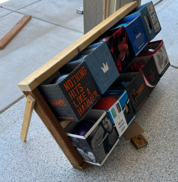 The Bola Graveyard: a wooden rack holding retired bolas after a game.